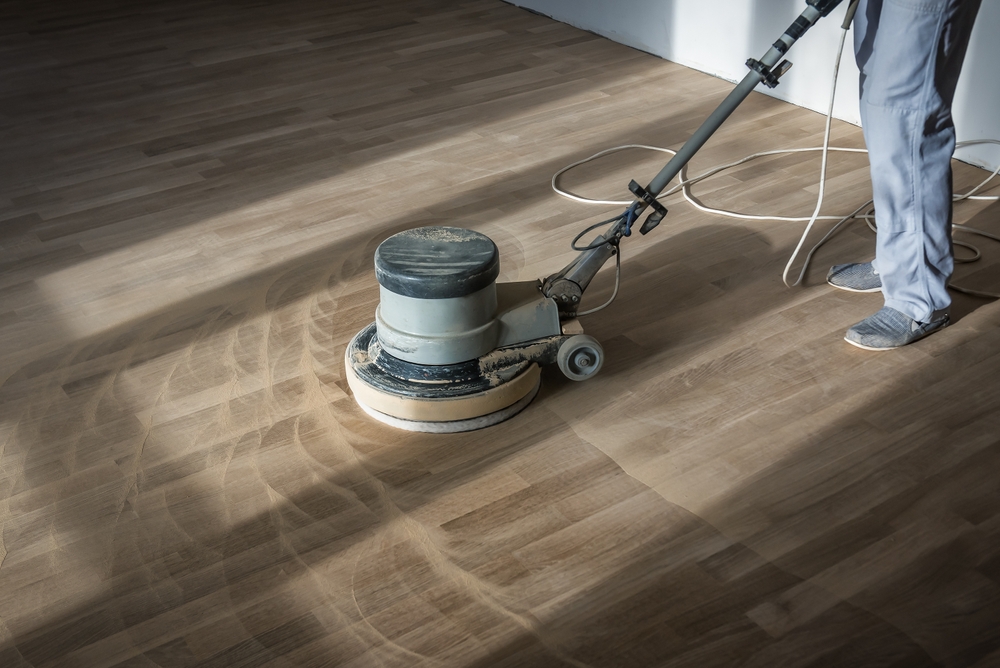A Professional Worker cleaning the Hardwood Floors in Long Island